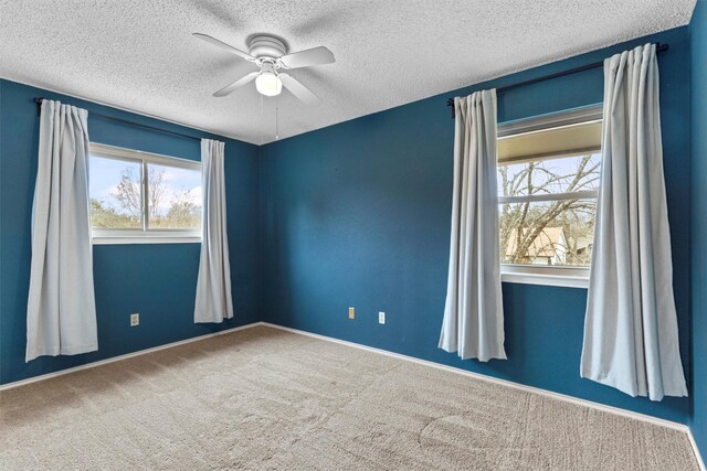 carpeted spare room with ceiling fan and a textured ceiling