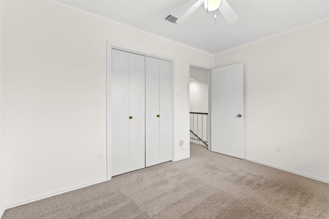 unfurnished bedroom with ceiling fan, ornamental molding, and light carpet