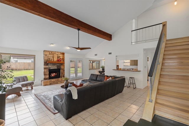 tiled living room featuring high vaulted ceiling, beam ceiling, and a stone fireplace