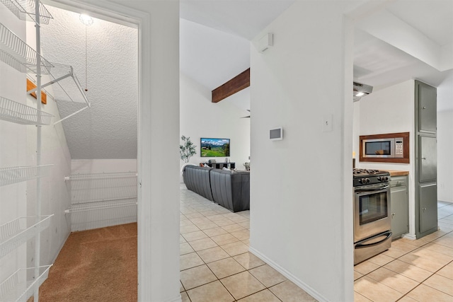 interior space with light tile patterned flooring and vaulted ceiling with beams