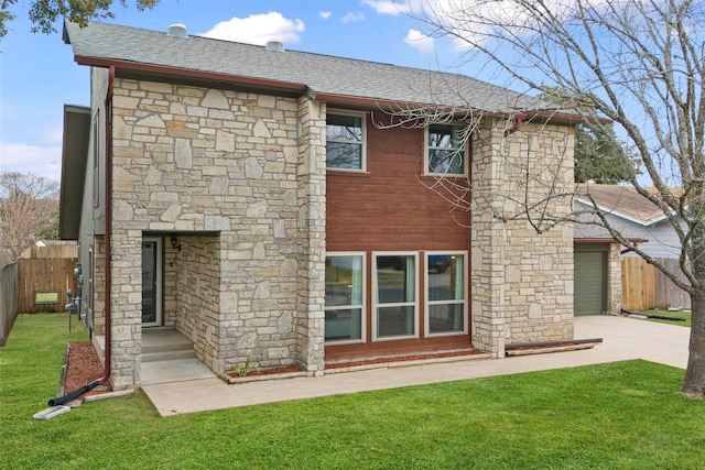 rear view of house with a garage and a lawn