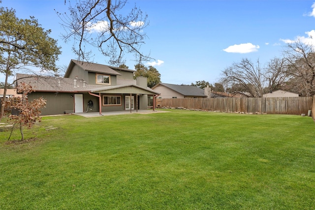 rear view of house featuring a patio area and a yard