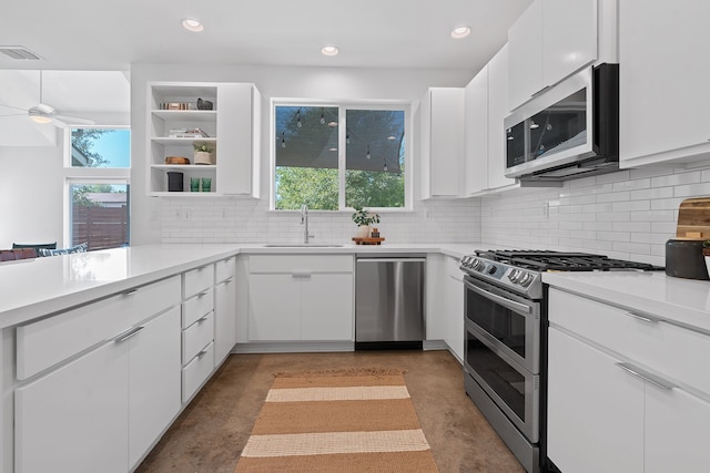 kitchen featuring white cabinets, appliances with stainless steel finishes, a healthy amount of sunlight, and sink