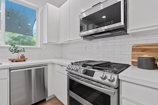 kitchen with white cabinets, stainless steel appliances, and backsplash