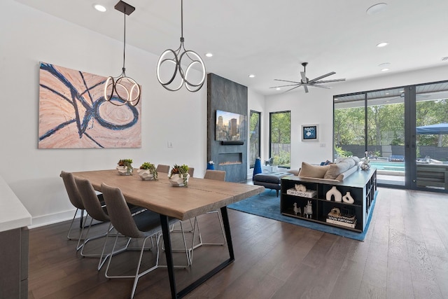 dining room with a large fireplace, baseboards, hardwood / wood-style flooring, and recessed lighting