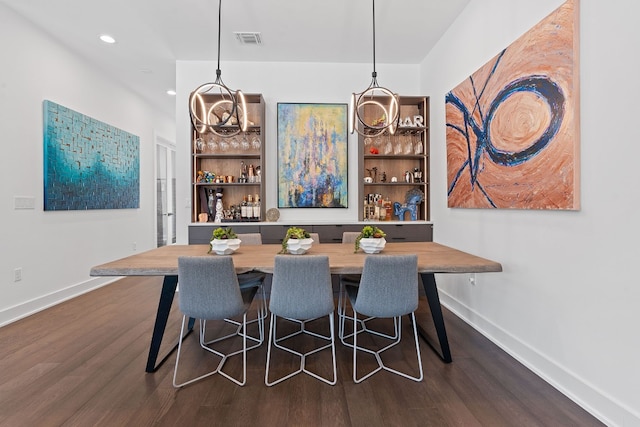 dining space with dark wood-style flooring, visible vents, and baseboards