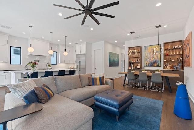 living room featuring baseboards, visible vents, dark wood-style flooring, and recessed lighting