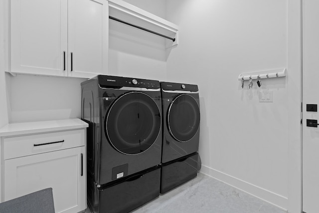 clothes washing area featuring cabinet space, baseboards, and independent washer and dryer