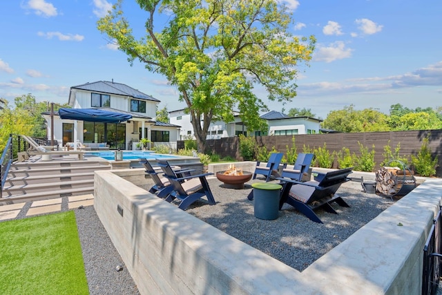 view of patio / terrace featuring an outdoor fire pit, a fenced backyard, and a fenced in pool