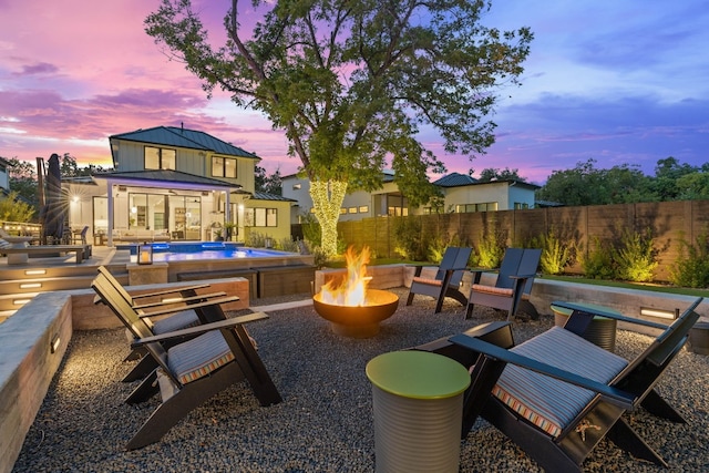 view of patio / terrace with an outdoor fire pit, a swimming pool, and a fenced backyard