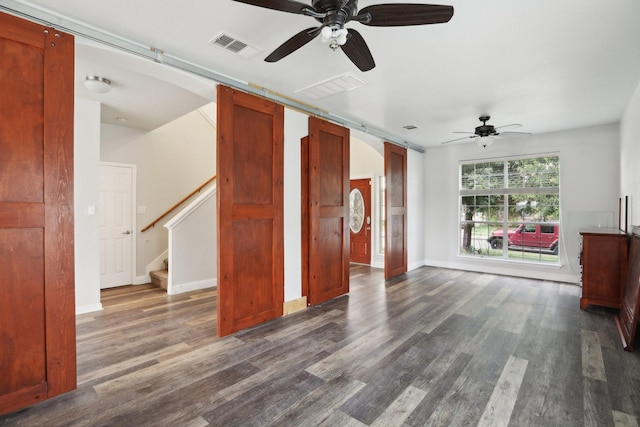 unfurnished living room featuring ceiling fan and dark hardwood / wood-style flooring