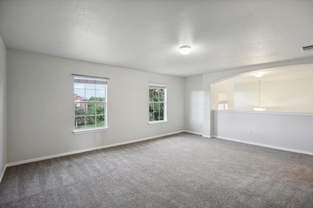 unfurnished room featuring a textured ceiling and carpet