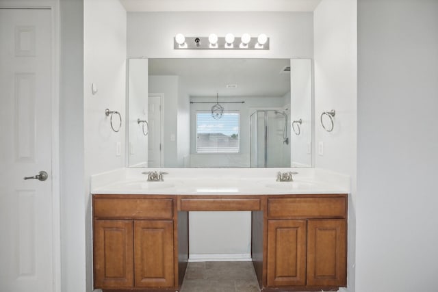 bathroom with a shower with door, vanity, and tile patterned flooring