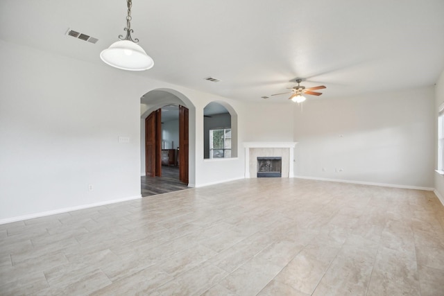 unfurnished living room featuring a fireplace and ceiling fan