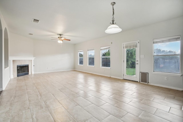 unfurnished living room featuring ceiling fan, light tile patterned flooring, and a fireplace