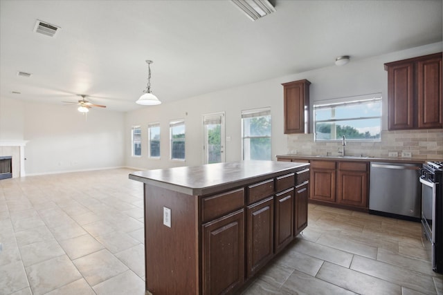 kitchen featuring dishwasher, decorative light fixtures, a kitchen island, backsplash, and sink