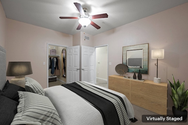 bedroom with ceiling fan, a walk in closet, a closet, and carpet flooring