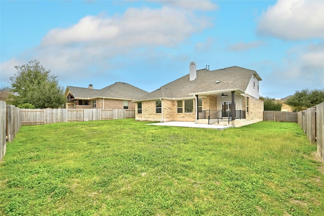 back of property with a patio area, ceiling fan, and a yard