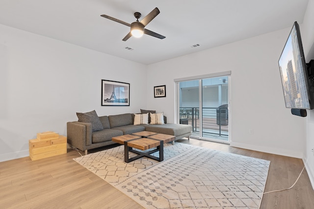 living room featuring ceiling fan and light hardwood / wood-style flooring