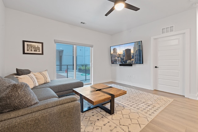 living room with ceiling fan and light hardwood / wood-style flooring