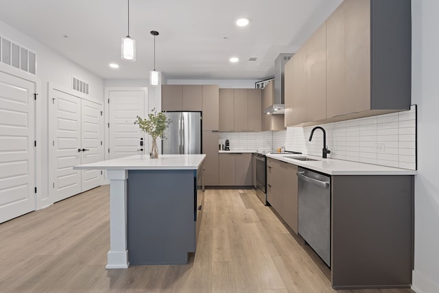 kitchen with stainless steel appliances, sink, hanging light fixtures, a kitchen island, and gray cabinetry