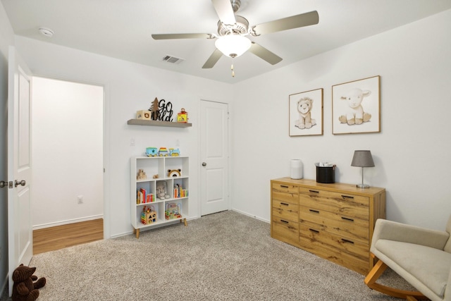 interior space with ceiling fan and light colored carpet