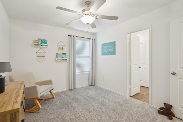 sitting room featuring ceiling fan and light colored carpet