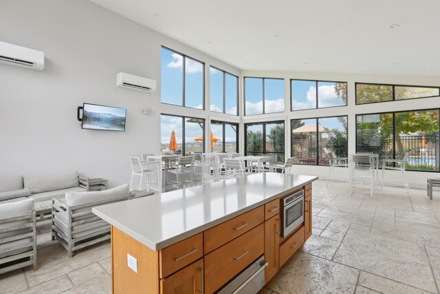 kitchen with stainless steel microwave, a wall mounted AC, and a healthy amount of sunlight