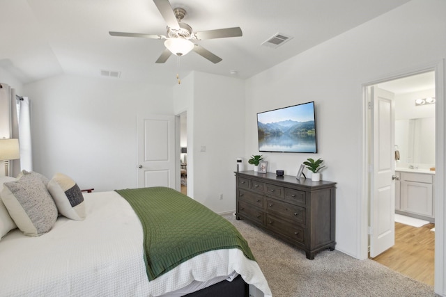 carpeted bedroom featuring ceiling fan, ensuite bathroom, and lofted ceiling