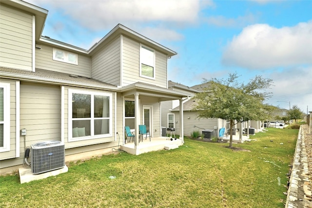 rear view of property with central air condition unit, a patio area, and a lawn