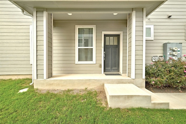 entrance to property with a lawn