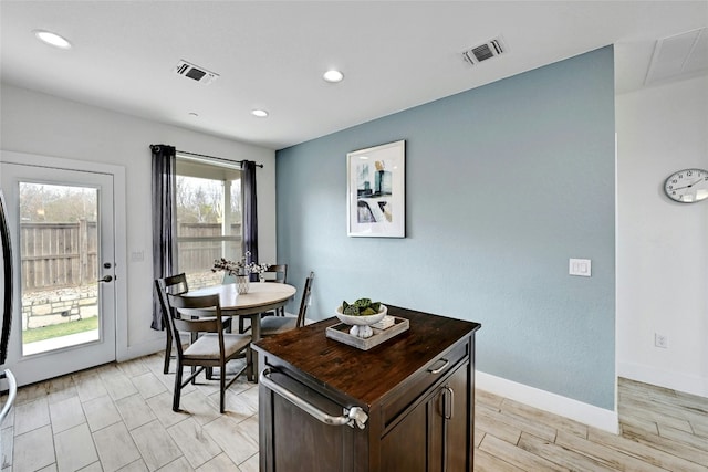 dining room featuring wood tiled floor, visible vents, and baseboards