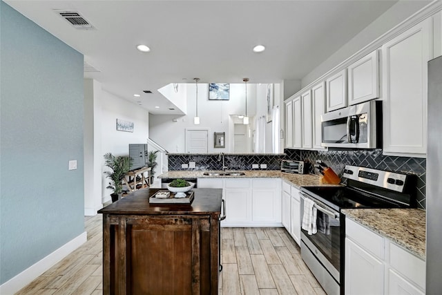 kitchen featuring visible vents, appliances with stainless steel finishes, and white cabinets