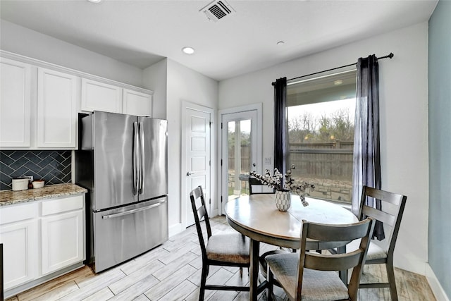 dining room featuring wood finish floors, recessed lighting, visible vents, and baseboards