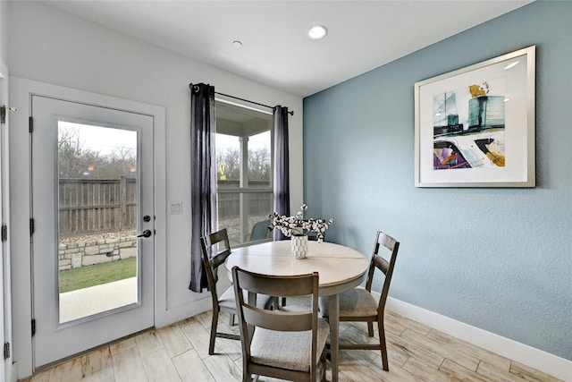 dining room featuring a wealth of natural light, baseboards, and light wood finished floors