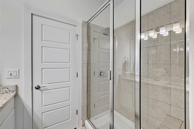 bathroom with a stall shower and vanity