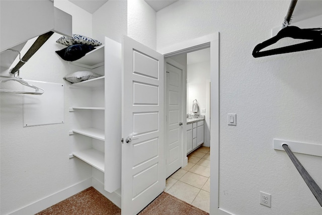 walk in closet featuring light colored carpet