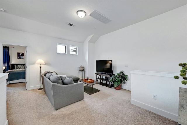 living area with baseboards, visible vents, and light colored carpet