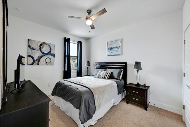 bedroom featuring light carpet, ceiling fan, and baseboards