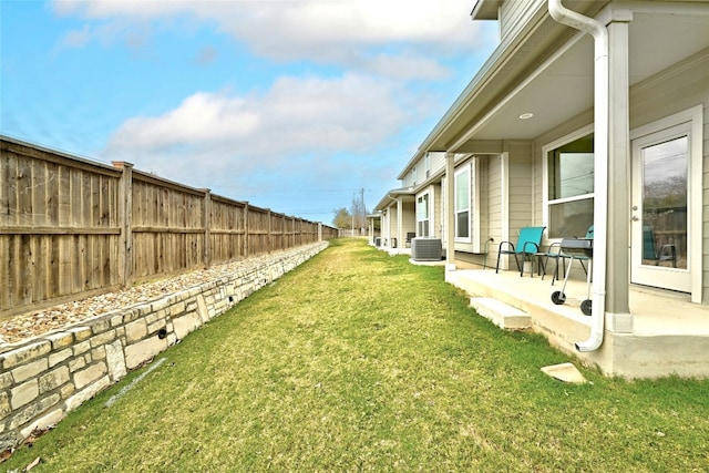 view of yard with fence private yard, a patio area, and cooling unit