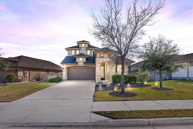 view of front of property featuring a garage and a lawn