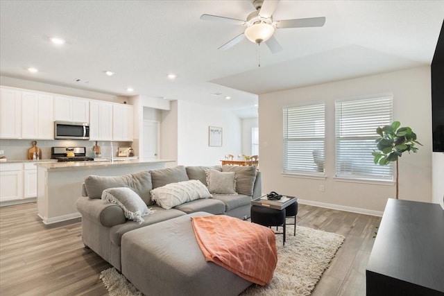 living room featuring light hardwood / wood-style floors and ceiling fan