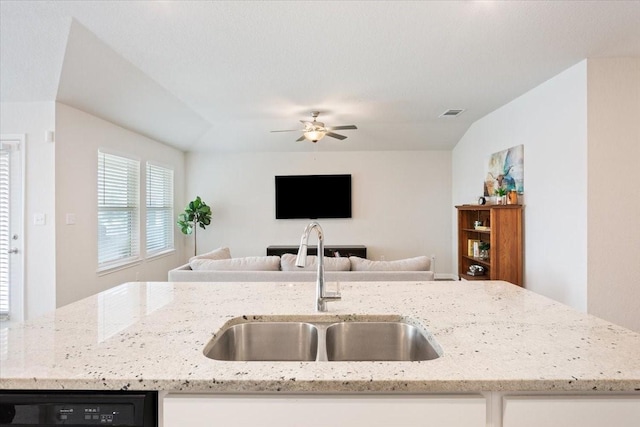 kitchen featuring sink, ceiling fan, dishwashing machine, and light stone countertops