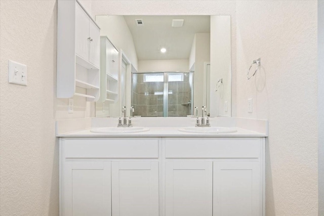 bathroom with vanity and a shower with shower door