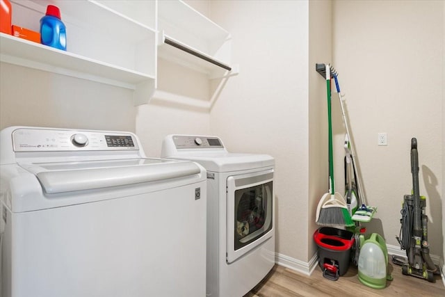 clothes washing area featuring light hardwood / wood-style floors and independent washer and dryer