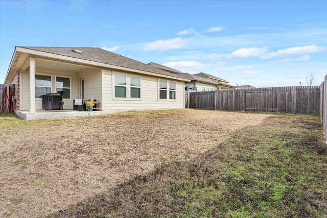 rear view of house with a lawn and a patio area