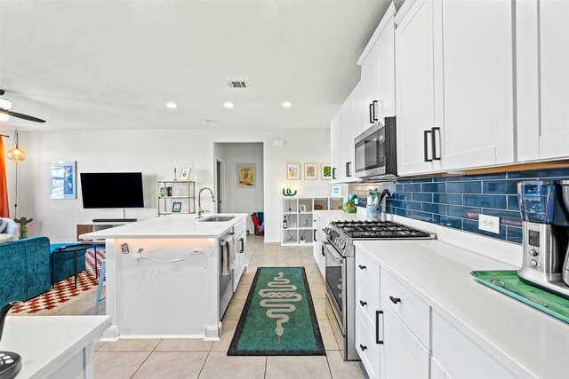 kitchen with sink, a center island with sink, white cabinetry, and appliances with stainless steel finishes