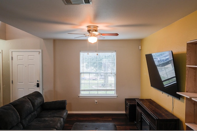 living room with ceiling fan and dark hardwood / wood-style flooring