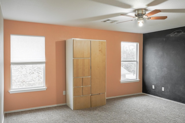 unfurnished bedroom with ceiling fan and carpet