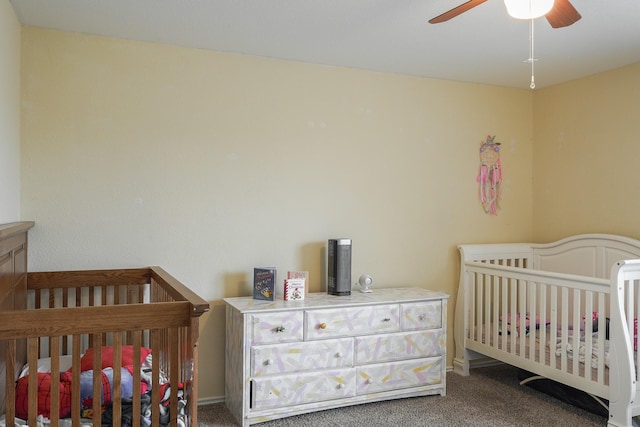 bedroom with a crib, ceiling fan, and carpet